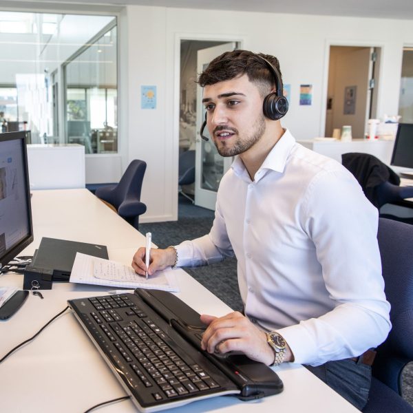 Mergim foran computer.