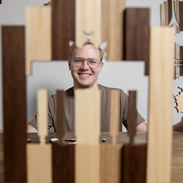 Jacob Lund der sidder bag træ kort, han har designet.