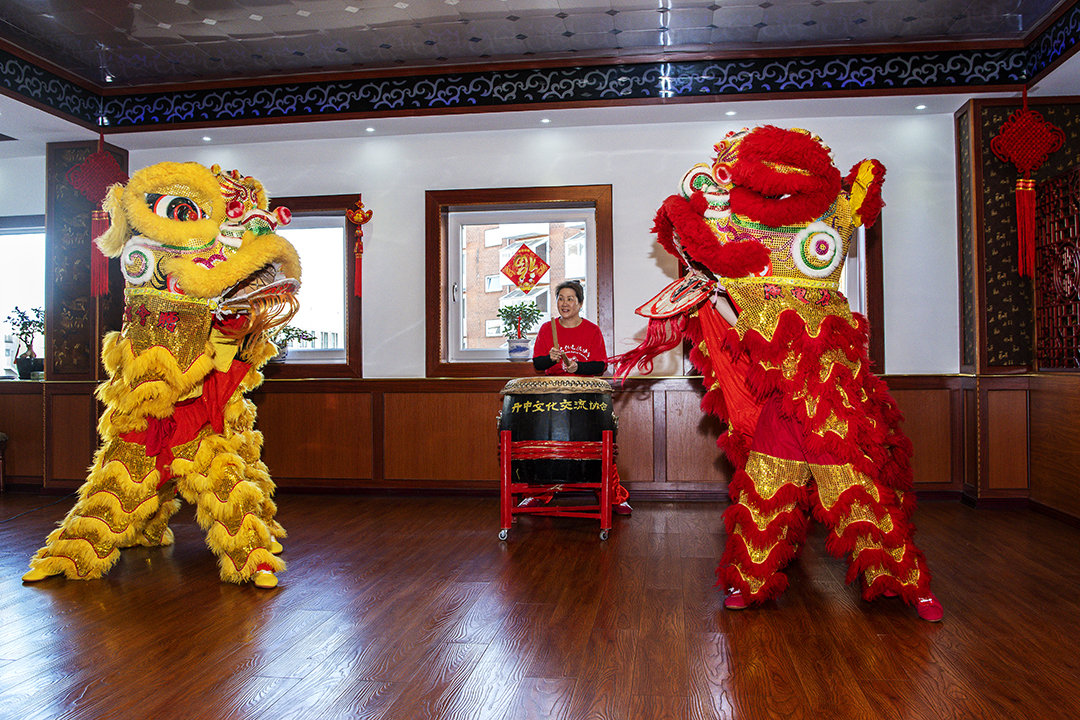 One musician and two dancer dressed af dragons