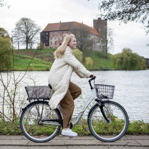 Billede af Mie Vestergaard, der cykler foran Kolding Hus.