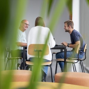 Tre studerende, der sidder og arbejder på en opgave i gruppe