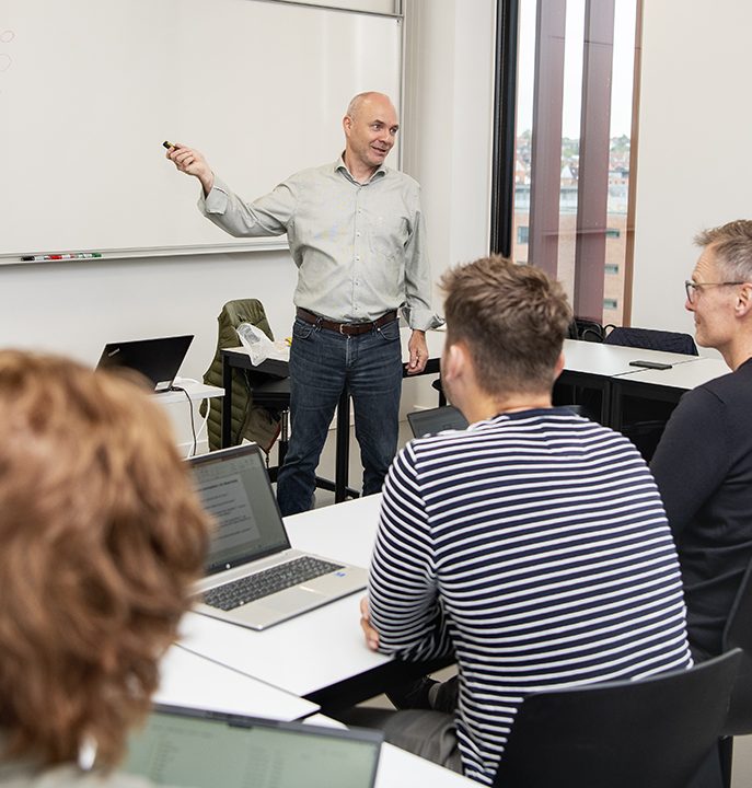 En underviser der forklarer noget for studerende