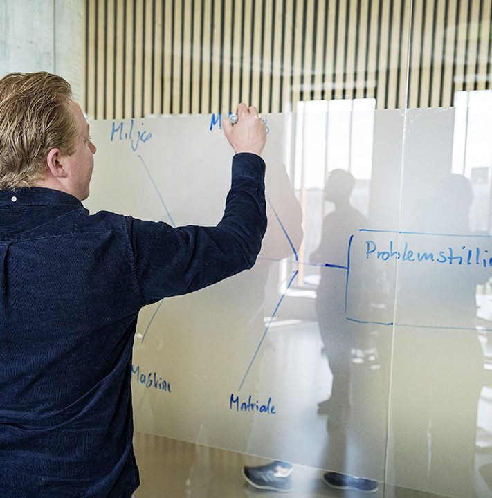 Studerende der skriver på det materede glas.