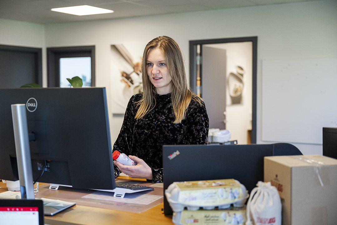 Louise Paarup der sidder foran en computer.