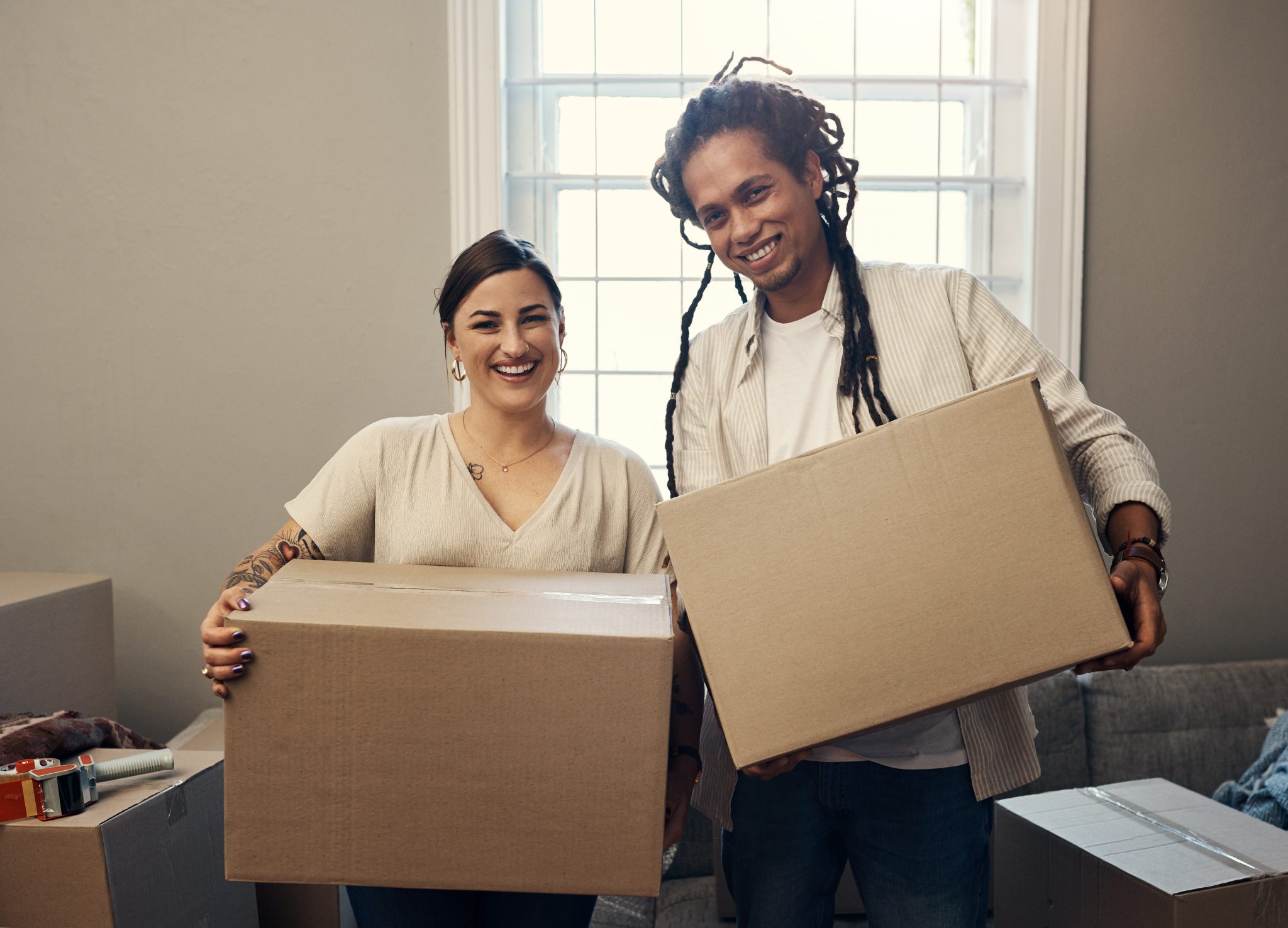 Couple holding moving boxes