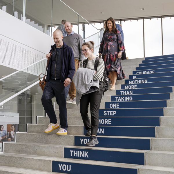 Studerende og underviser der går ned ad trappen fra 6. etage på IBA.