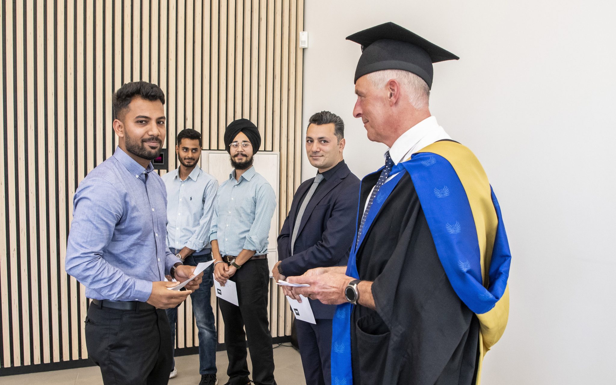 Picture of Course Director, Peter Lei, with students at graduation ceremony.