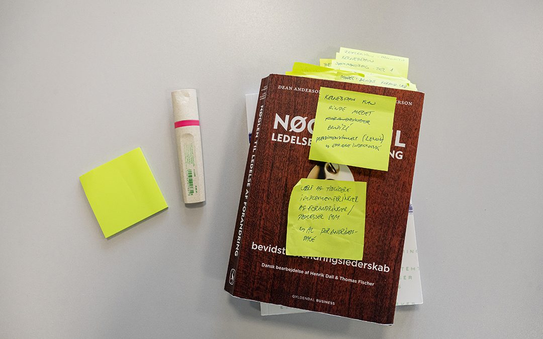 En lærebog, klistret ind i post-it sedler, og en highlighter.