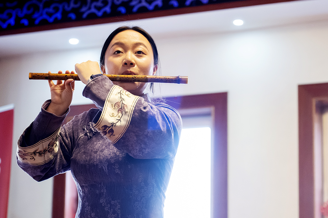 Wenting Xu playing on a bamboo flute.