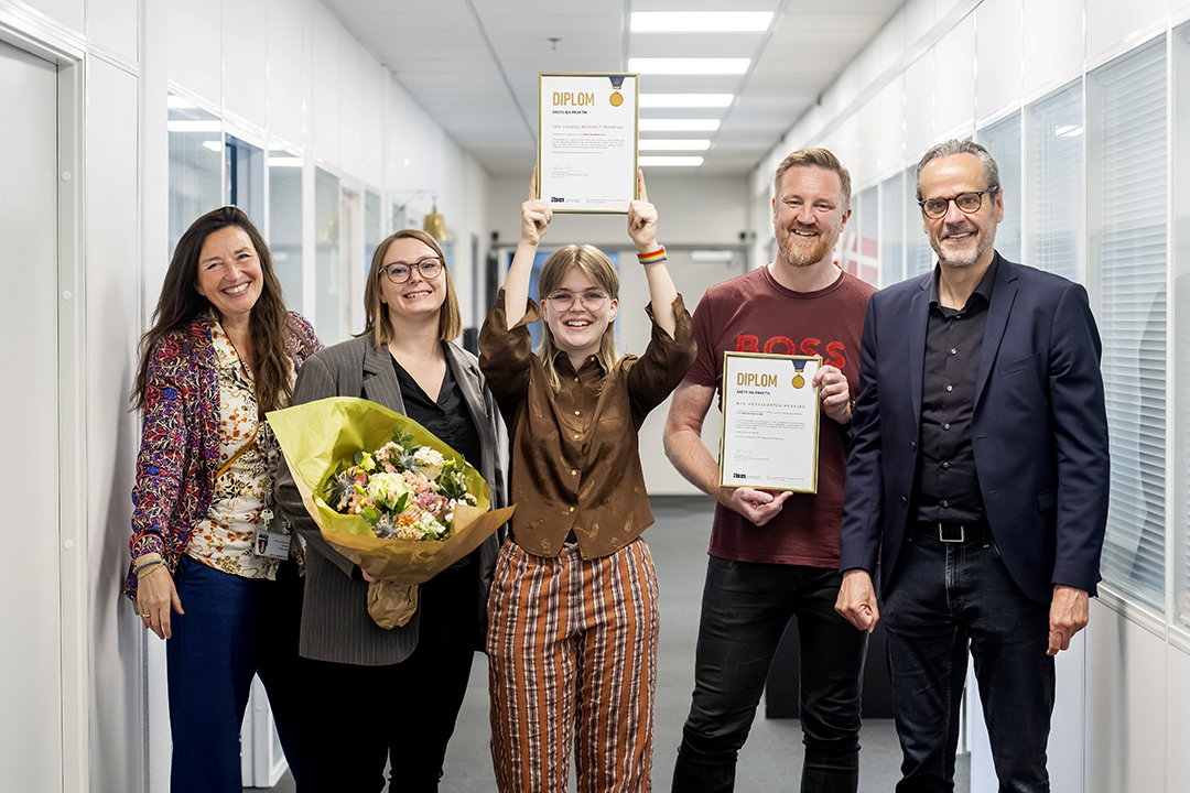 Foto af Line, med sit diplom og praktikvejleder samt uddannelseschef på IBA
