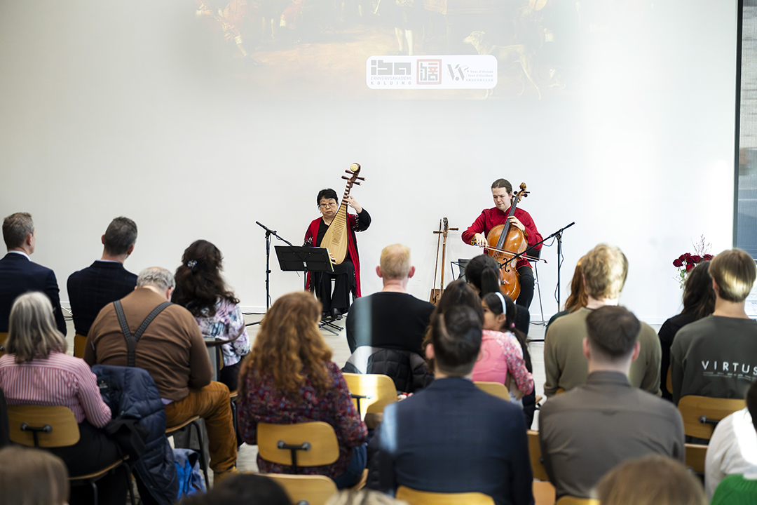 Foto af et 4-mands orkester, der står på en scene og spiller