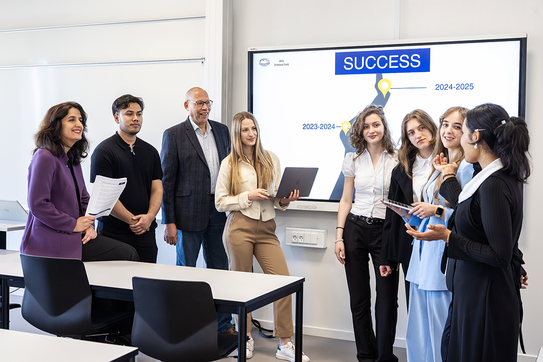 Photo of students and their lecturer standing in a classroom