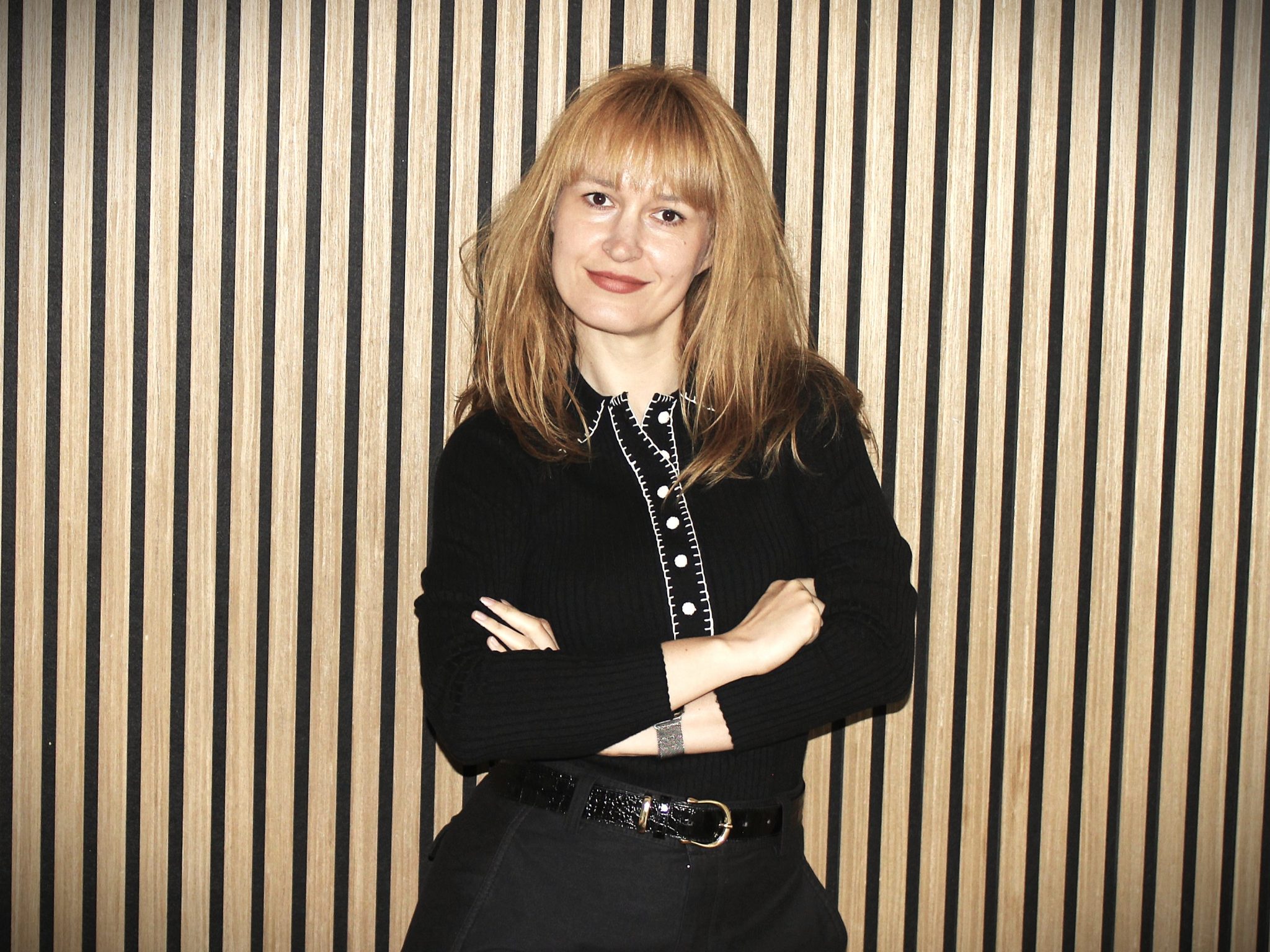 Foto af Larisa, der står op ad en væg